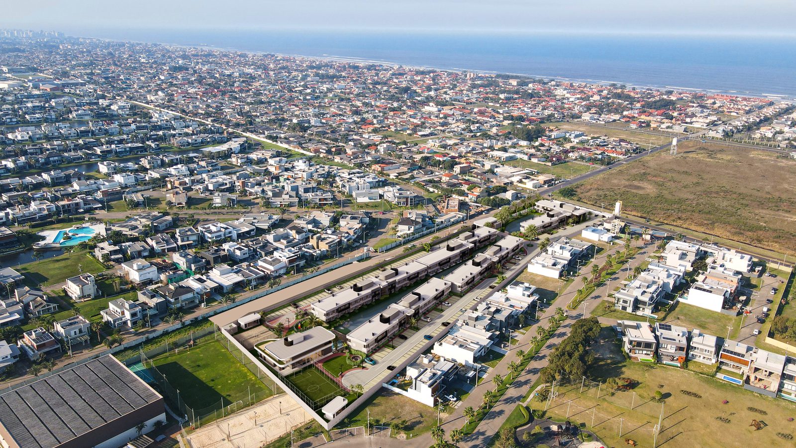 Vista aérea da região, com o condomínio em primeiro plano e o mar ao fundo