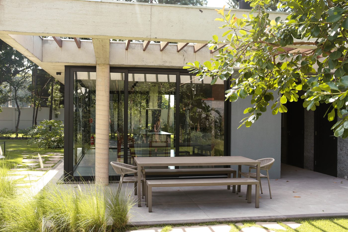 Mesa externa do espaço gourmet, sob pergolado de concreto