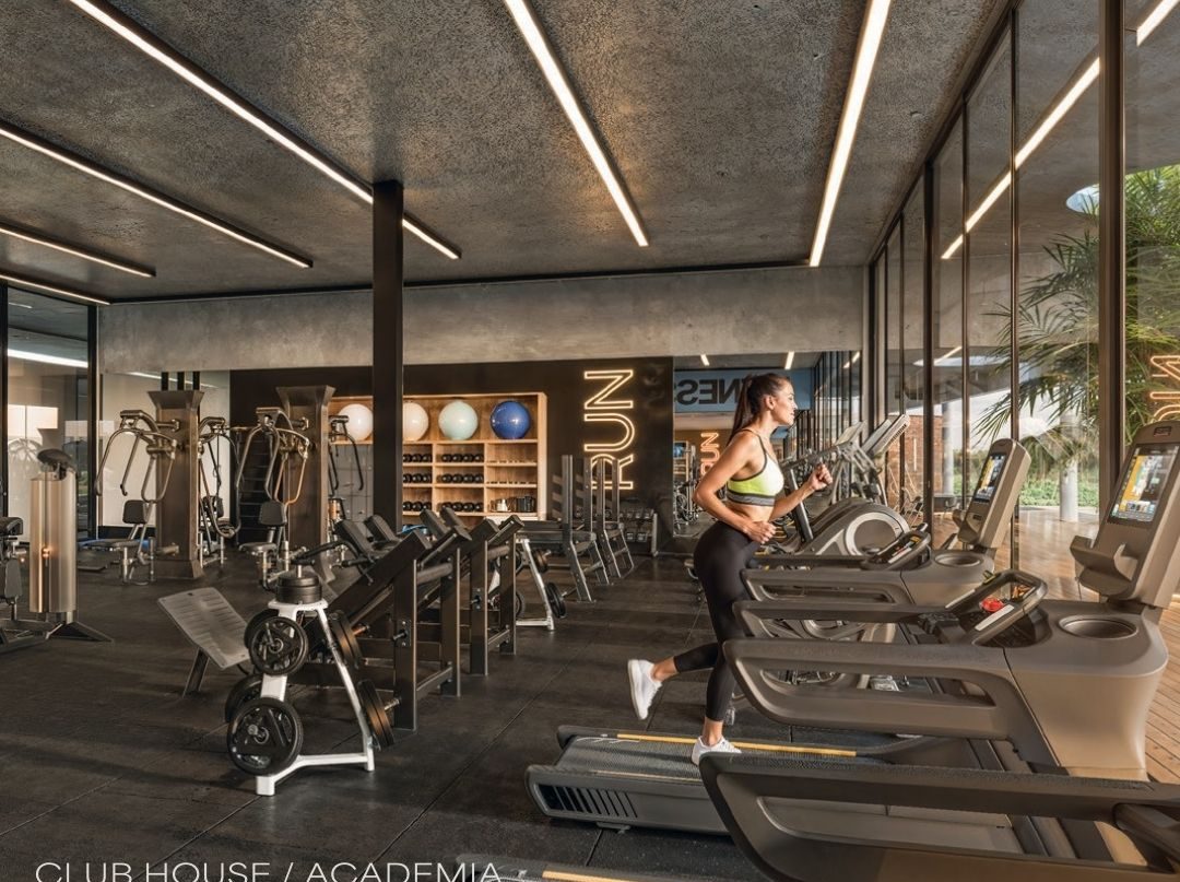 Academia do club house, envidraçada, com vista para o verde