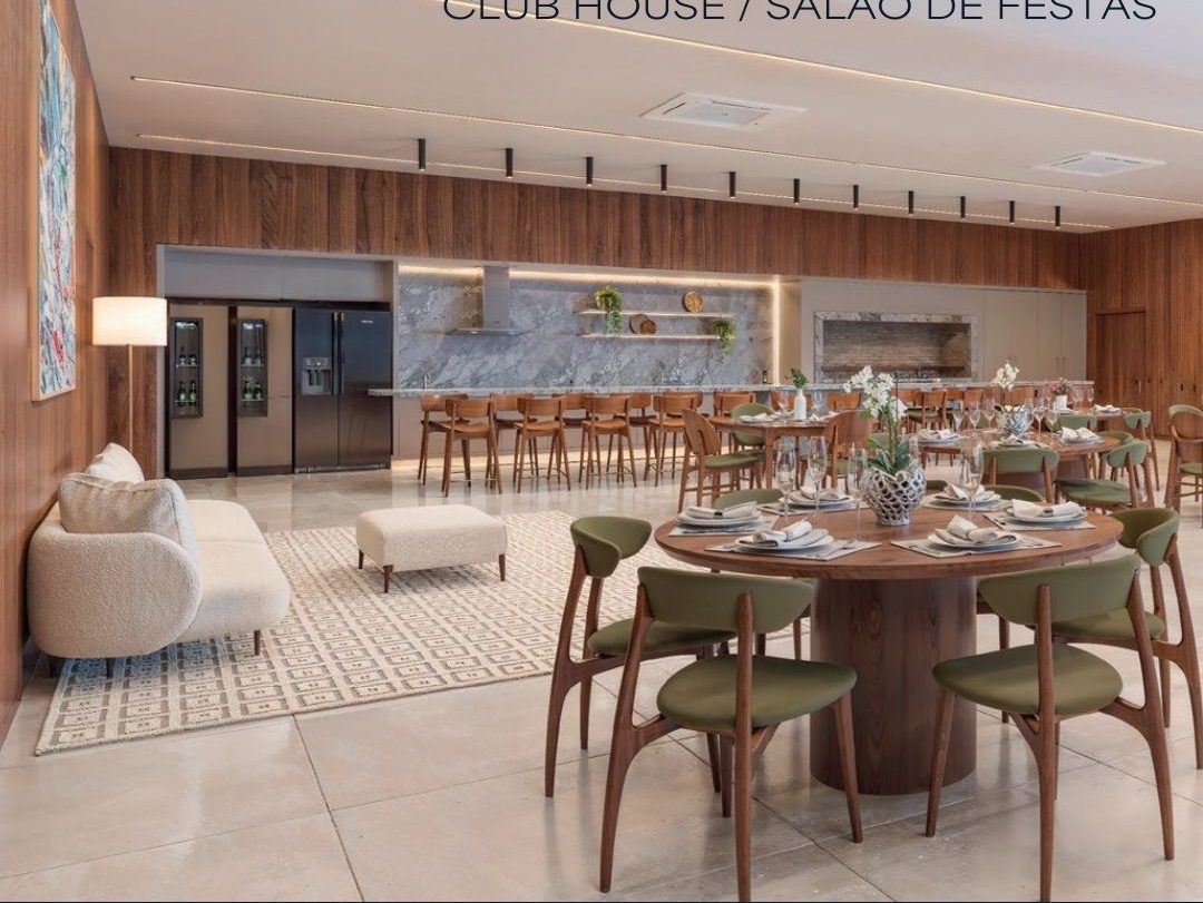 Salão de festas com mesa posta, cozinha ao fundo e marcenaria de madeira