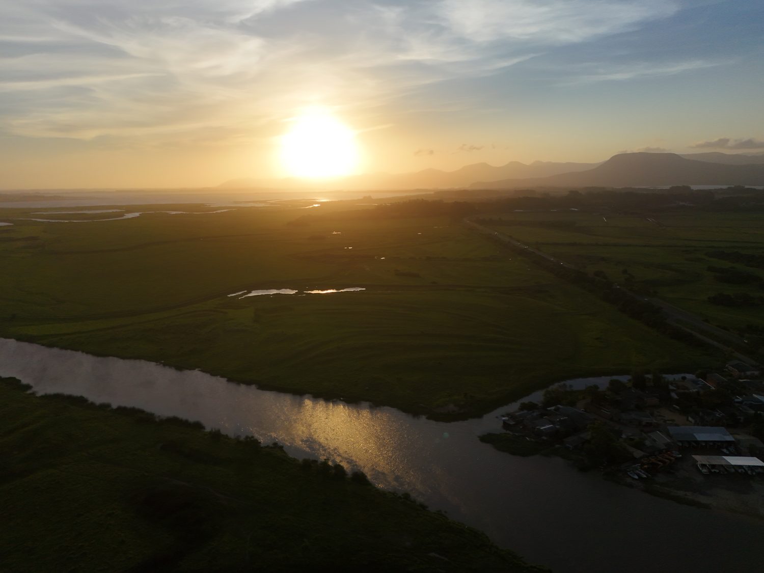 Entardecer sobre o rio, com as montanhas ao fundo