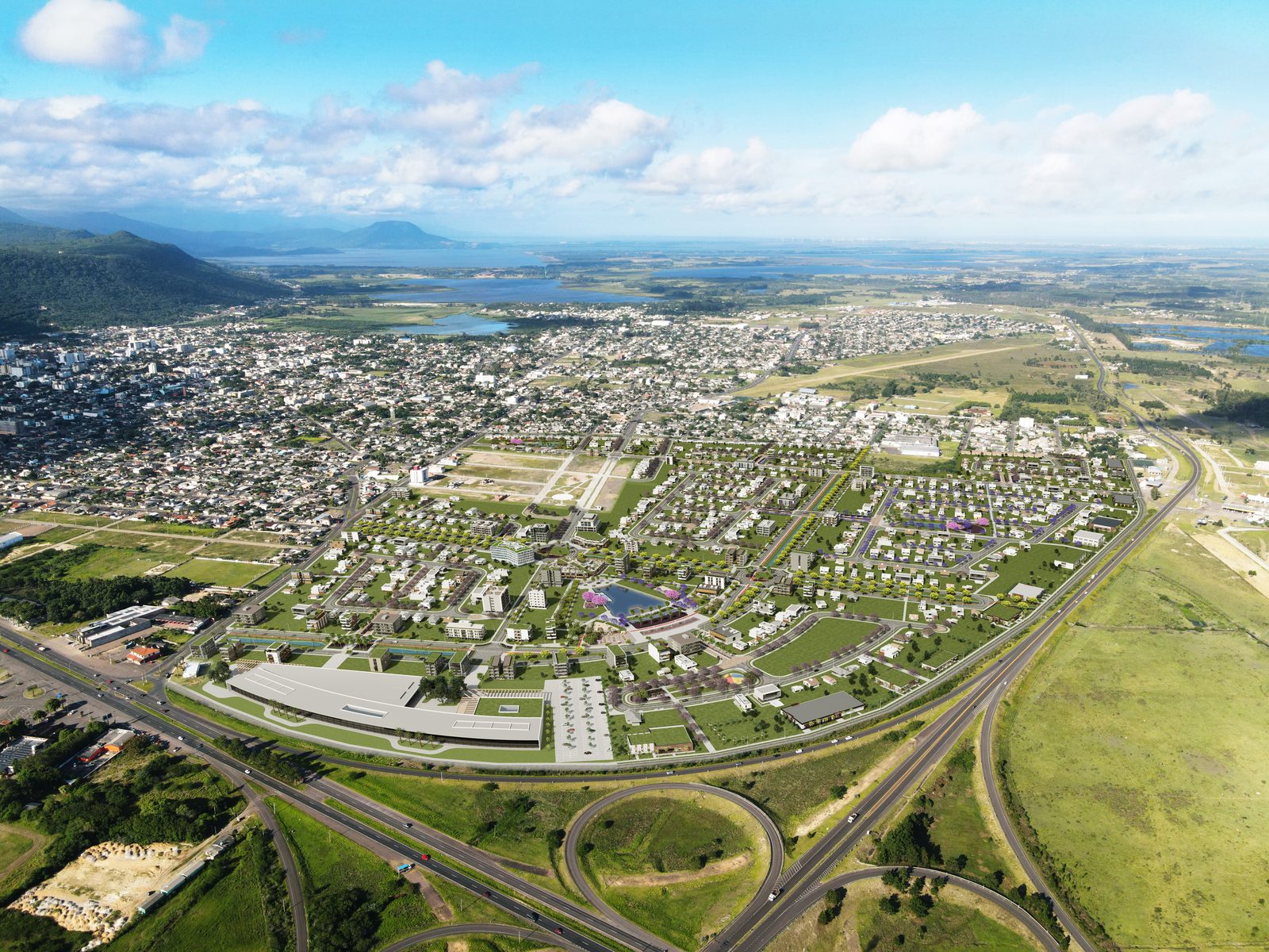 Vista aérea do bairro planejado em Osório, junto ao trevo rodoviário, com a serra e as lagoas ao fundo