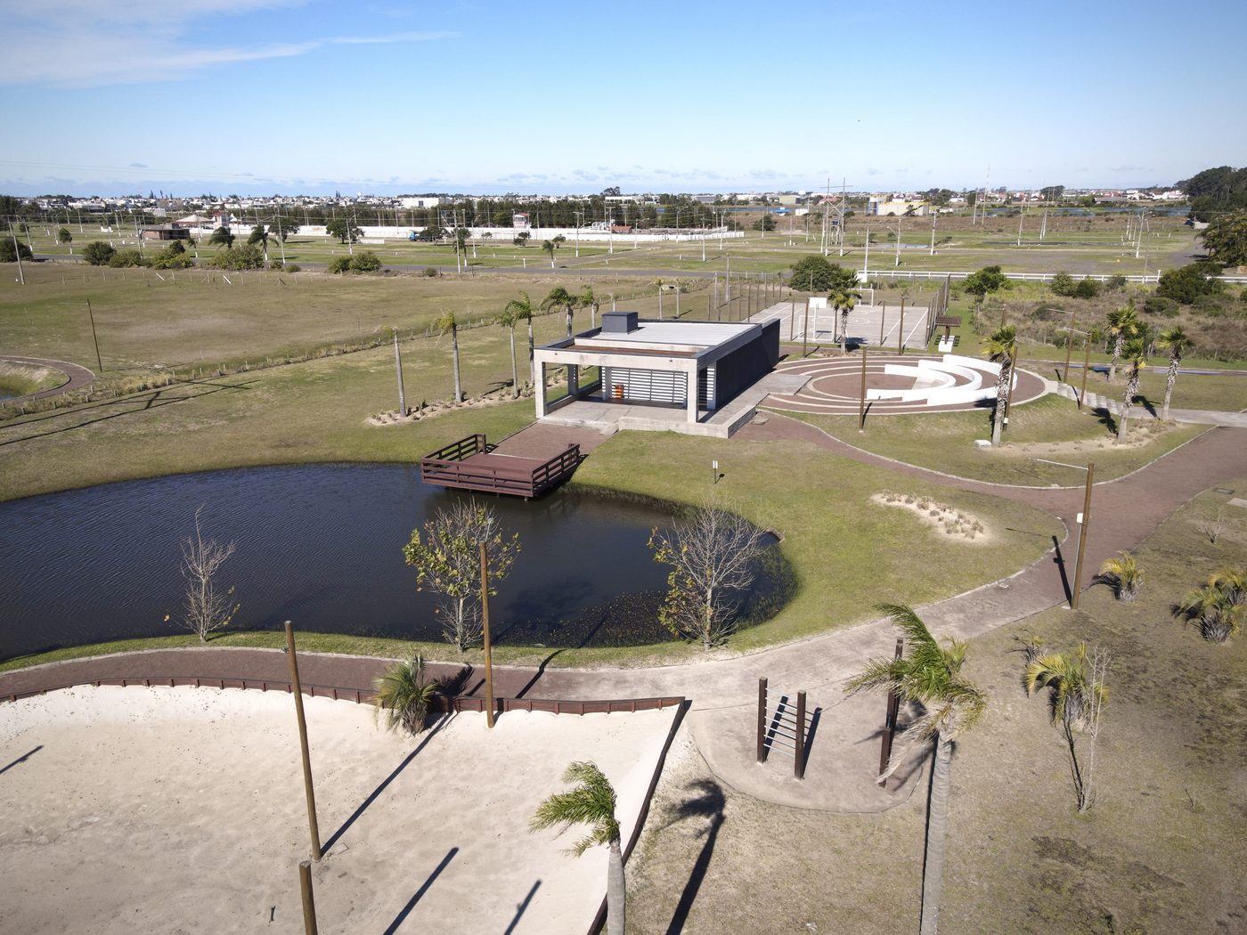 Deck de madeira sobre o lago, com pavilhão e areia na margem