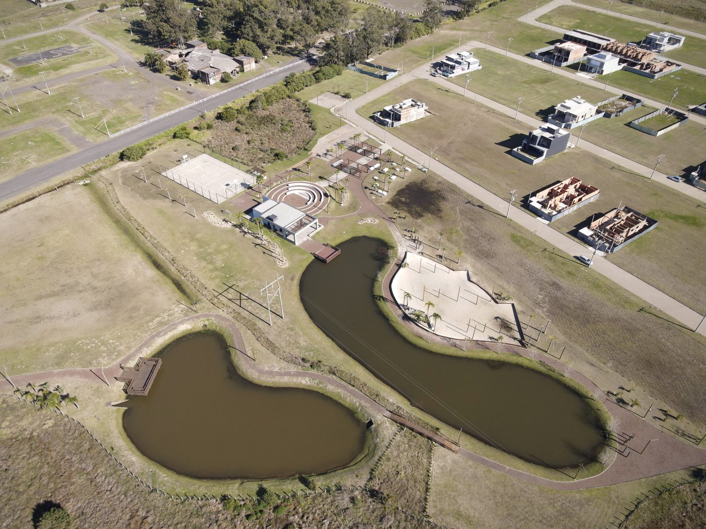 Casas já construídas à beira do lago, com a praia de areia