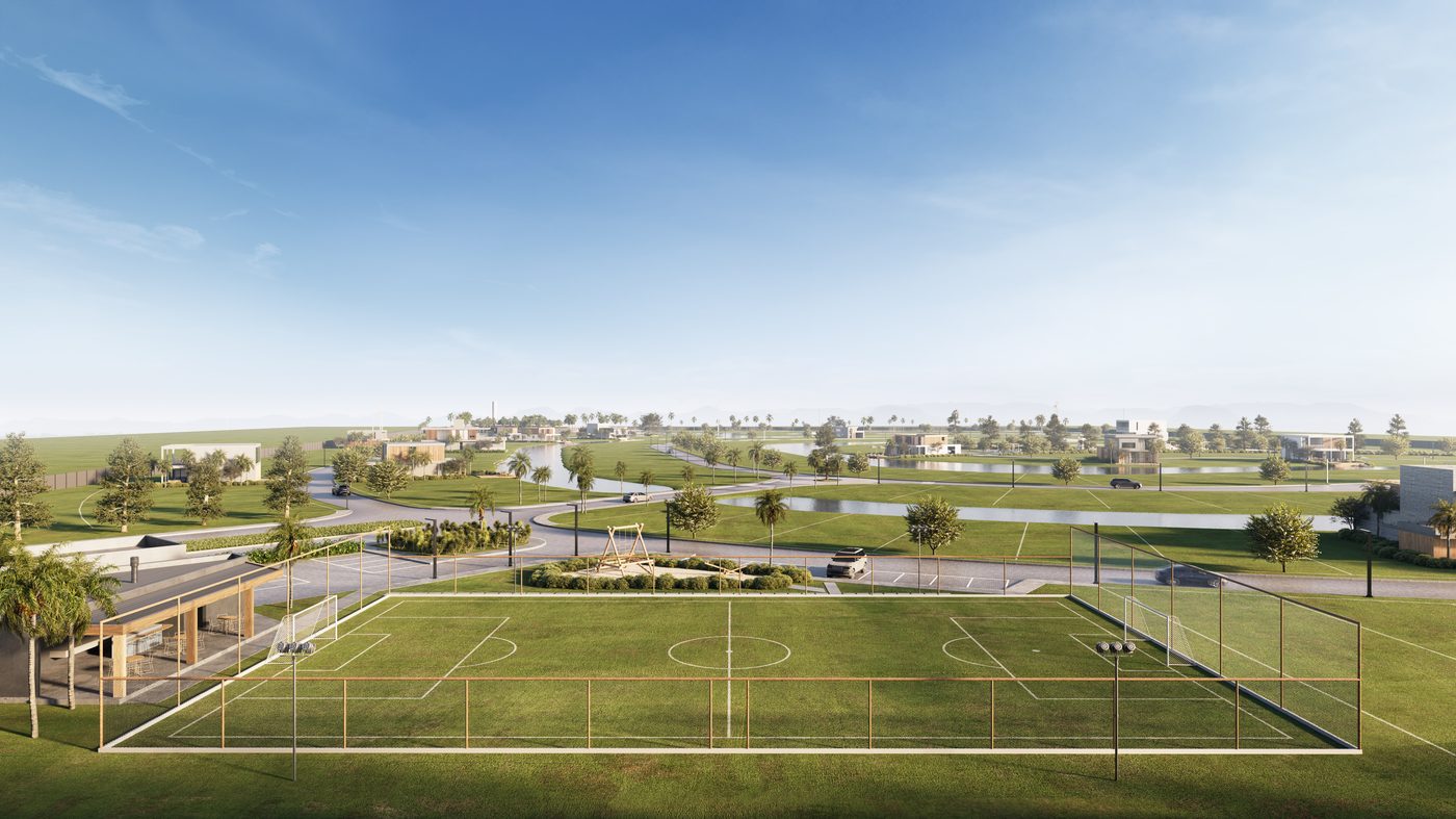 Campo de futebol e playground, com os lotes e o lago ao fundo