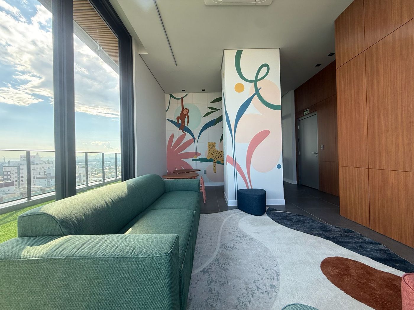 Espaço kids com painel colorido e vista para a cidade