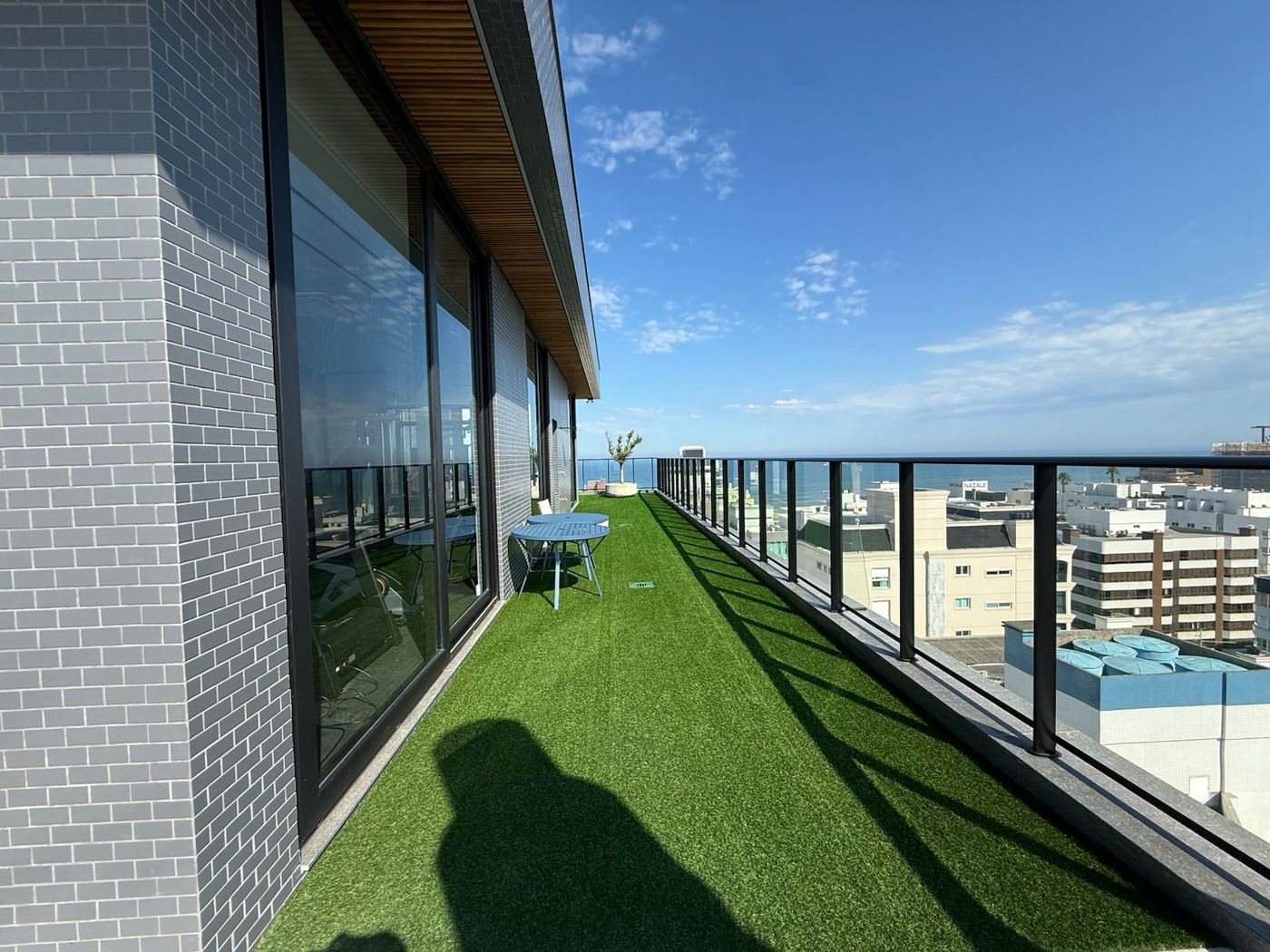 Terraço gramado do rooftop com vista para a cidade
